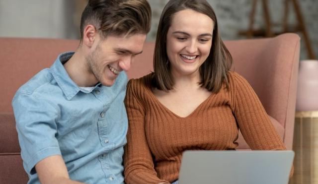 年轻夫妇看着他们的笔记本电脑.